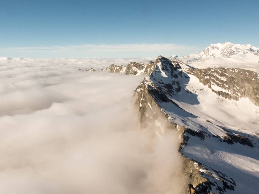 Blick von oben auf den Portjengrat über den Wolken